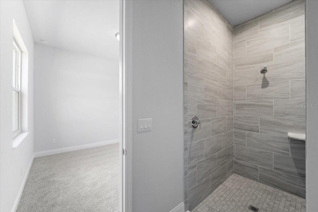 bathroom with tiled shower and a wealth of natural light