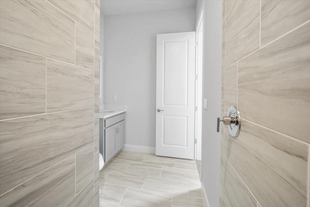 bathroom featuring tile patterned floors, vanity, and tile walls