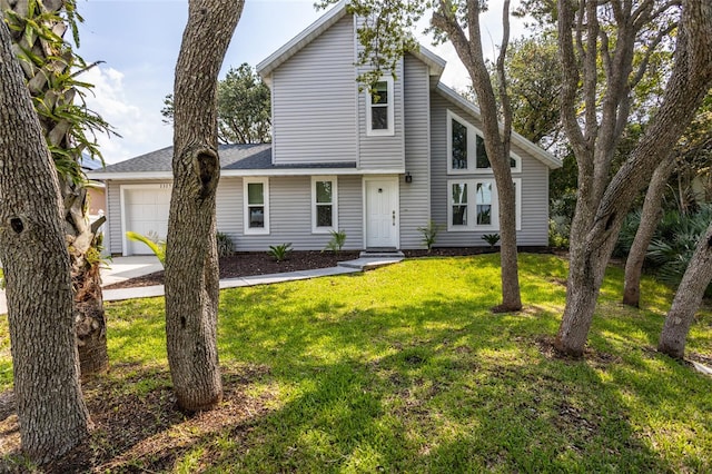 view of property with a garage and a front lawn