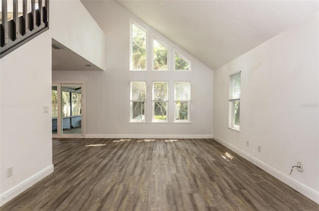 unfurnished living room featuring high vaulted ceiling and dark wood-type flooring