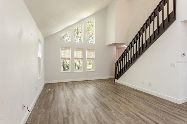 unfurnished living room with hardwood / wood-style flooring and high vaulted ceiling