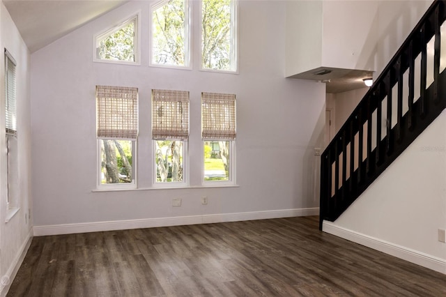 unfurnished living room featuring dark wood-type flooring and vaulted ceiling