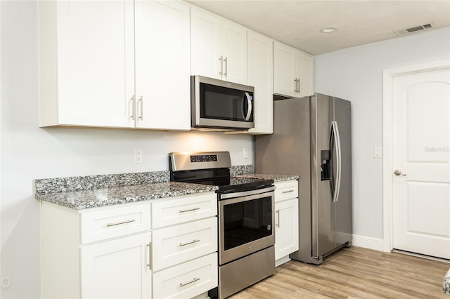 kitchen with white cabinetry, appliances with stainless steel finishes, light stone countertops, and light hardwood / wood-style floors