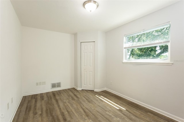 unfurnished room with dark hardwood / wood-style floors