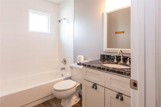 full bathroom featuring vanity, tiled shower / bath, wood-type flooring, and toilet