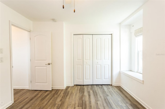 unfurnished bedroom featuring wood-type flooring and a closet