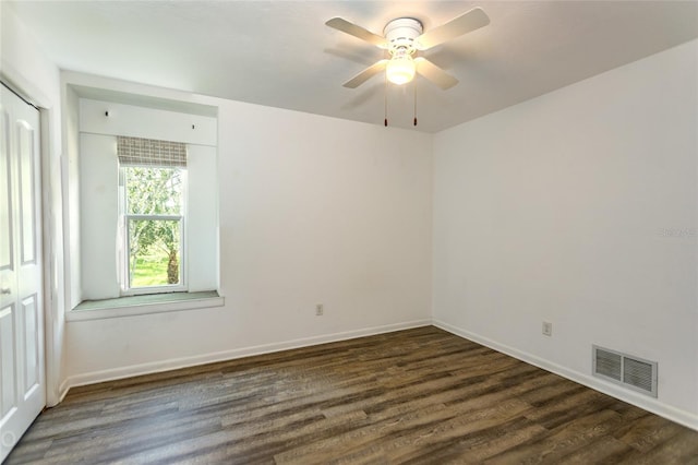 empty room with ceiling fan and dark hardwood / wood-style floors