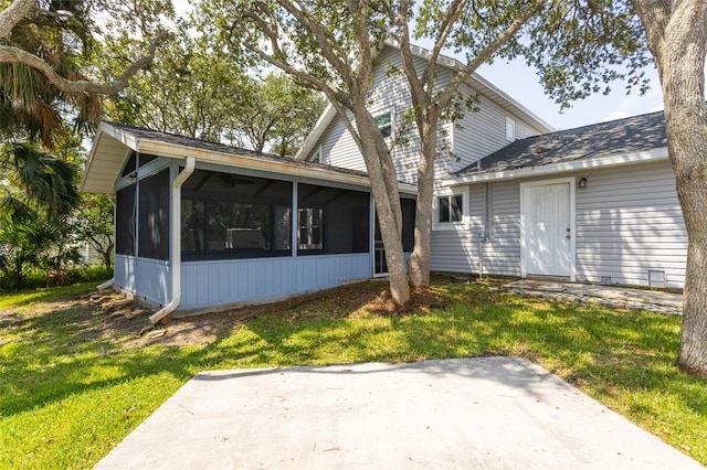 rear view of property with a yard and a sunroom