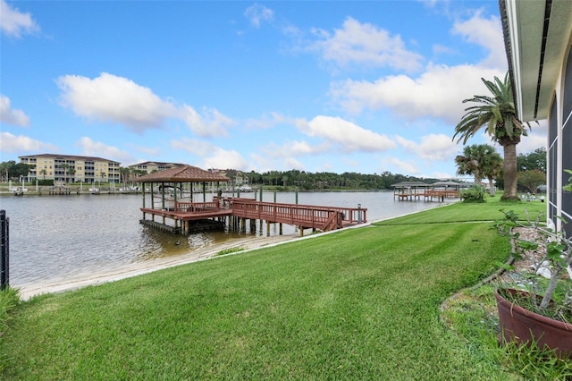 dock area with a lawn and a water view