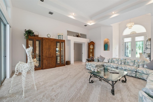 living area featuring visible vents, a raised ceiling, a high ceiling, carpet flooring, and french doors