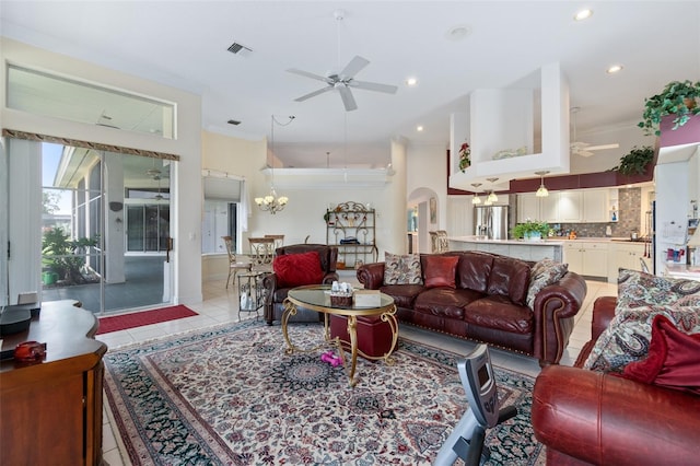 living room featuring arched walkways, ornamental molding, light tile patterned flooring, and a ceiling fan