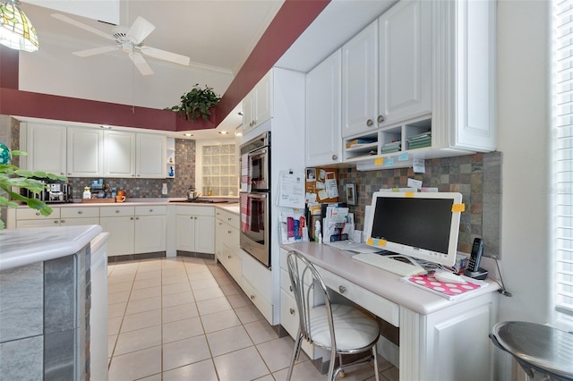 kitchen with light countertops, white cabinetry, backsplash, and light tile patterned floors