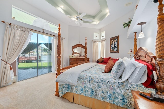 bedroom featuring ceiling fan, access to outside, a raised ceiling, and light colored carpet