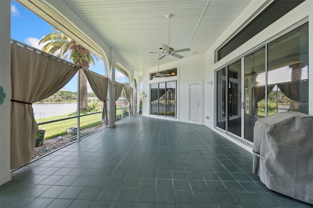 view of patio / terrace with ceiling fan, a water view, and a grill