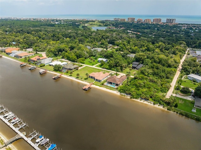 drone / aerial view featuring a water view and a wooded view