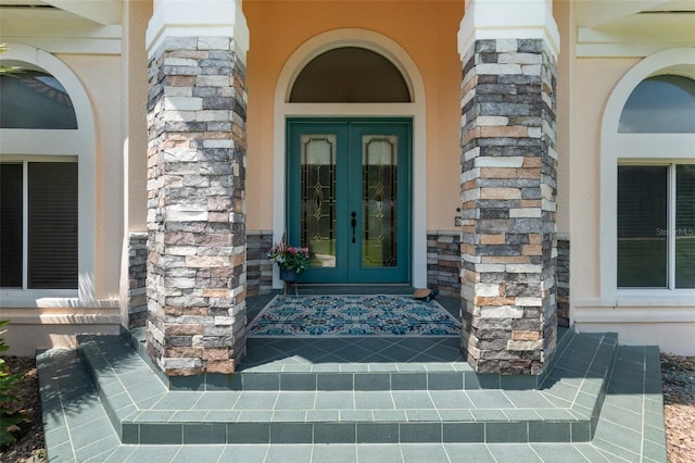 doorway to property featuring stone siding and french doors