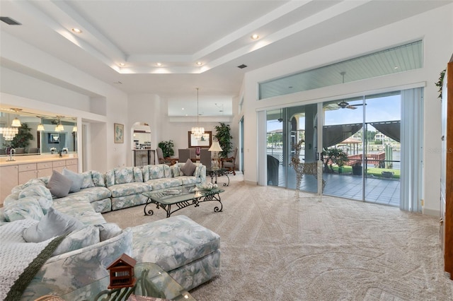 living area featuring recessed lighting, a raised ceiling, visible vents, carpet flooring, and a chandelier