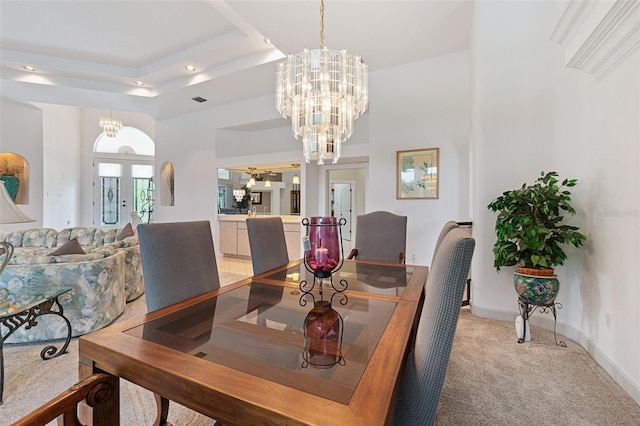 dining area featuring light carpet, baseboards, a raised ceiling, french doors, and a notable chandelier