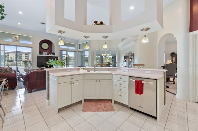 kitchen featuring decorative light fixtures, light countertops, open floor plan, a sink, and dishwasher