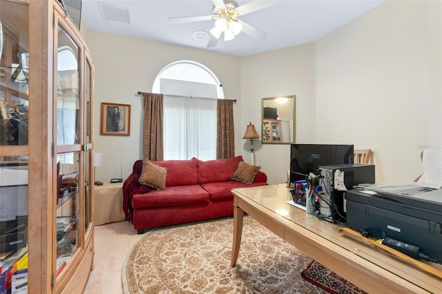 living room with light carpet, visible vents, and a ceiling fan