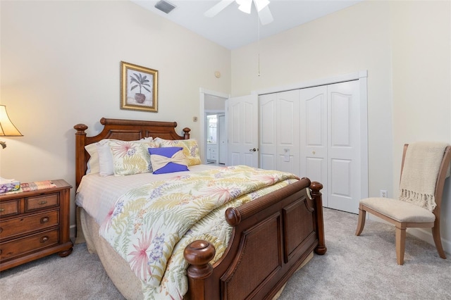 bedroom featuring a closet, light colored carpet, ceiling fan, and visible vents