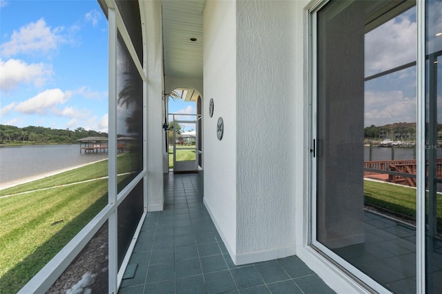 unfurnished sunroom with a water view