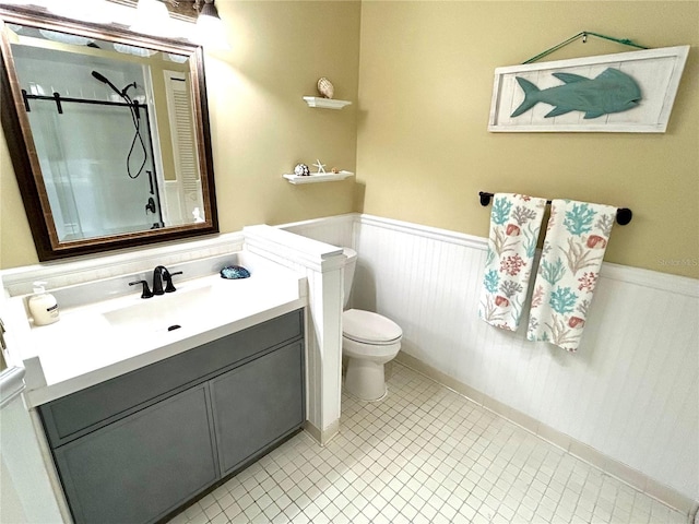 54 Rivers Edge Ln, Palm Coast, FL 32137 - full bathroom with wainscoting, a shower, toilet, vanity, and tile patterned flooring