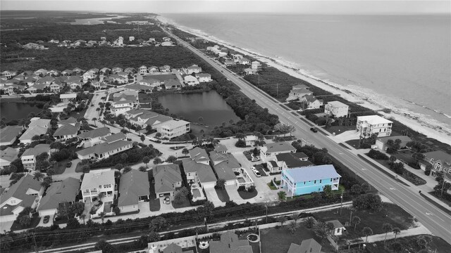 drone / aerial view with a water view and a beach view