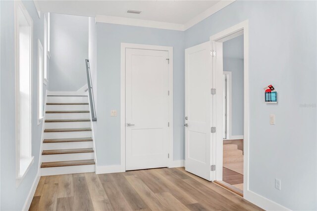 interior space with ornamental molding and light hardwood / wood-style flooring