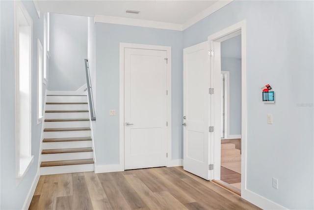 entrance foyer featuring baseboards, stairs, visible vents, and wood finished floors