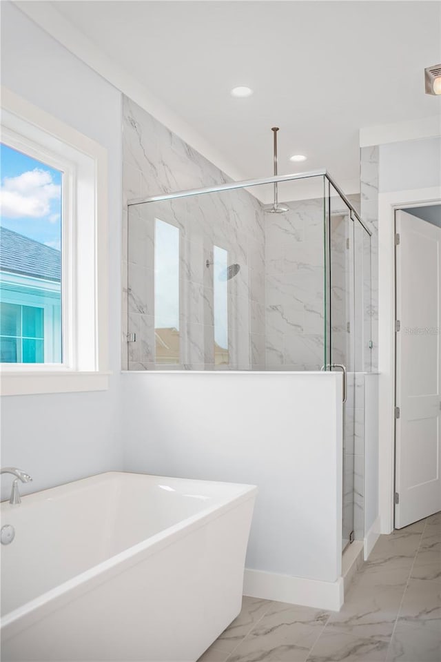 full bath featuring marble finish floor, a shower stall, a freestanding tub, and recessed lighting