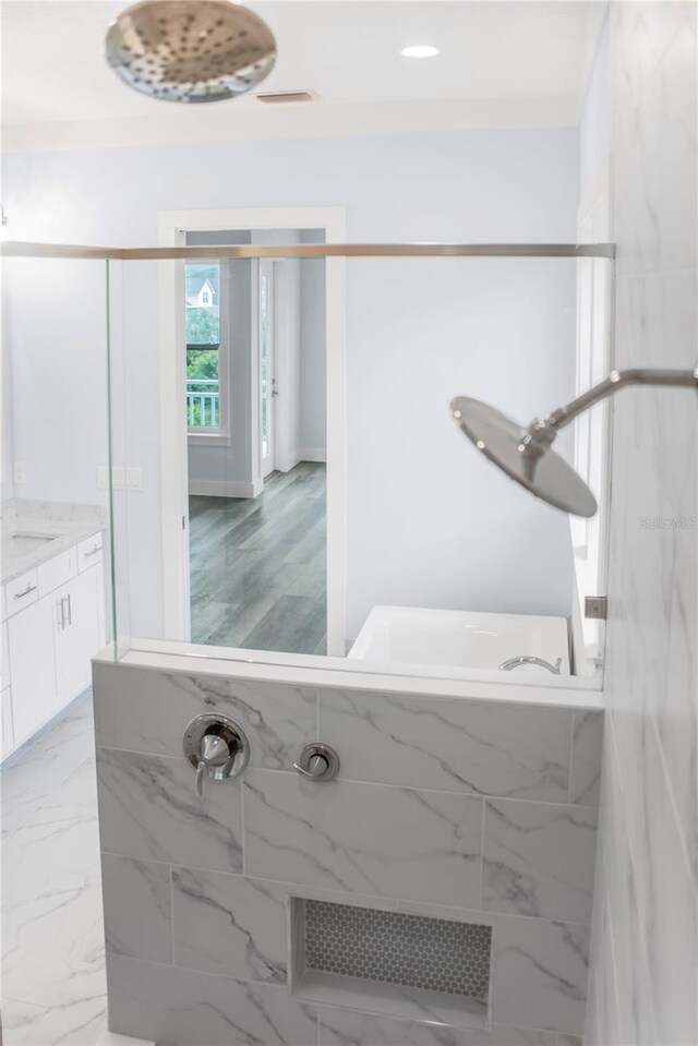 bathroom featuring vanity, separate shower and tub, and hardwood / wood-style floors