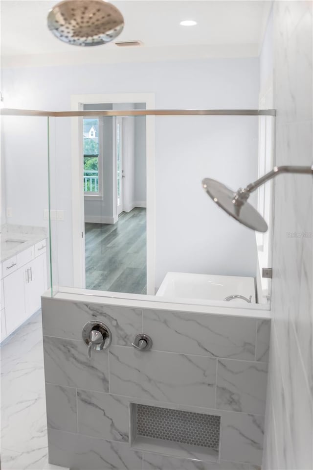 full bath featuring marble finish floor, visible vents, a shower, and vanity