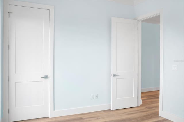 unfurnished bedroom featuring light wood-type flooring and baseboards