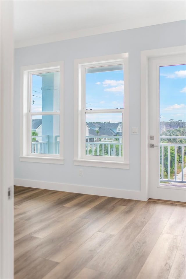 empty room with light wood-type flooring and baseboards