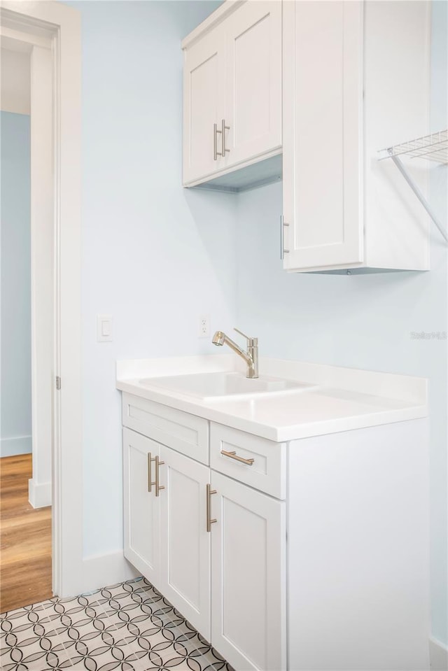laundry area featuring a sink and baseboards