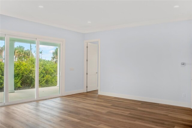 spare room featuring baseboards and wood finished floors