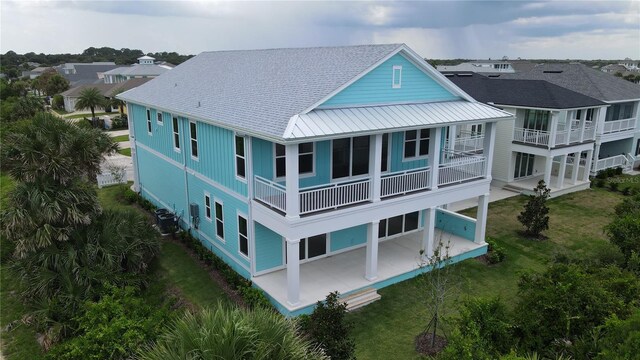 back of house featuring central AC, a patio area, and a balcony