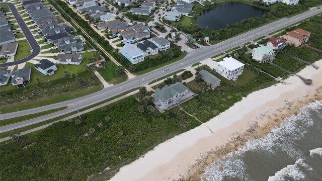 birds eye view of property with a water view and a view of the beach