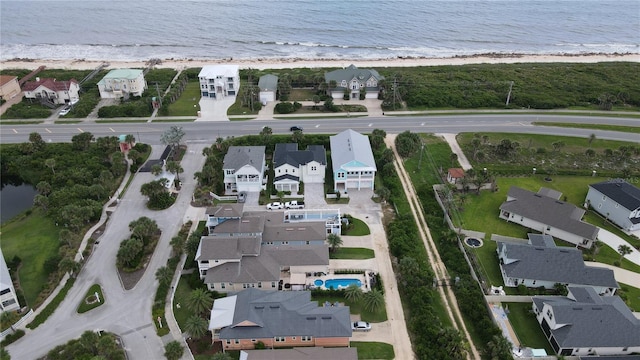 drone / aerial view featuring a water view, a residential view, and a view of the beach