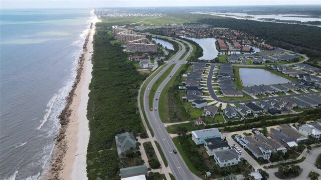 drone / aerial view featuring a beach view and a water view