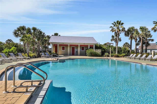 pool with a patio area and fence