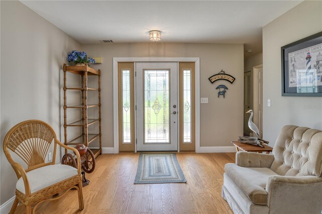 foyer entrance with baseboards, visible vents, a wealth of natural light, and light wood-type flooring