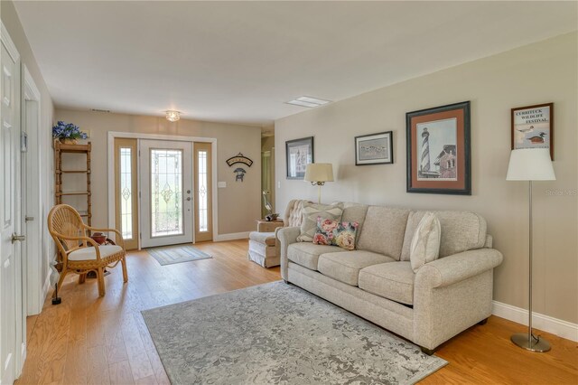 living area with baseboards and light wood finished floors