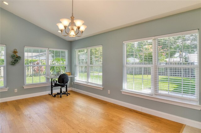 unfurnished room with an inviting chandelier, baseboards, light wood-type flooring, and lofted ceiling