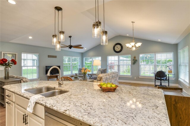 kitchen with a wealth of natural light, open floor plan, wood finished floors, and a sink