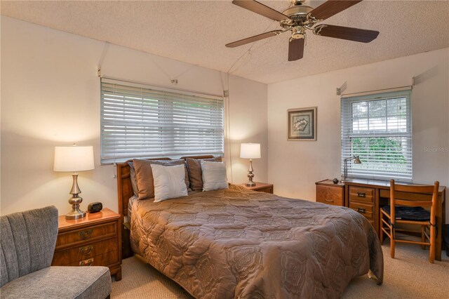 carpeted bedroom with a ceiling fan and a textured ceiling