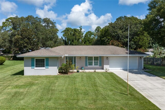 ranch-style house with an attached garage, concrete driveway, a front lawn, and fence