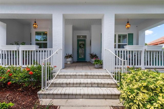 view of exterior entry featuring covered porch