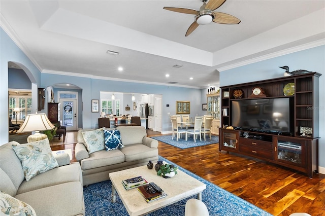 living room with ceiling fan, a raised ceiling, ornamental molding, and hardwood / wood-style floors